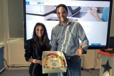 Nathalie Bechay (HP Inc. Nederland) overhandigt taart aan Marcel van den Berg (Vitasys)