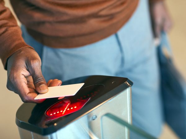 man met toegangspas bij poortje